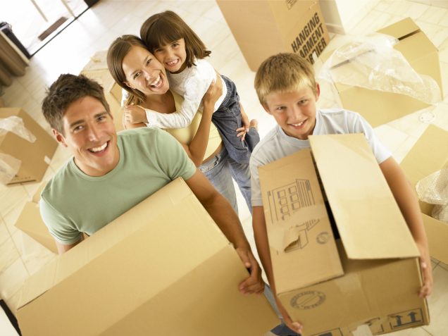 A family holding boxes in a room while looking for apartments in Katy TX.