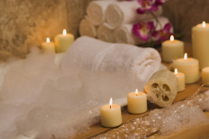 An inviting bath tub adorned with candles, soap, and flowers, perfect for unwinding in luxurious apartments for rent in Katy.