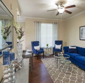 A cozy living room in Katy, Texas apartments with blue couches and a ceiling fan.