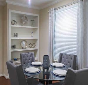 A dining room with a glass top table and chairs located in Katy, Texas Apartments.